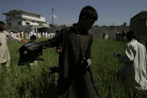 A Pakistani youngster collects metal pieces from a wheat field outside the house where al-Qaida leader Osama bin Laden lived in Abbottabad, Pakistan. Residents of this sleepy hill town in northwest Pakistan, named after a British colonial officer, are still trying to come to grips with their newfound infamy as home to one of the greatest mass murderers in modern history.